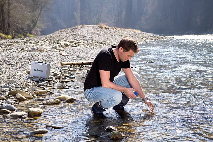 Man taking water sample in river